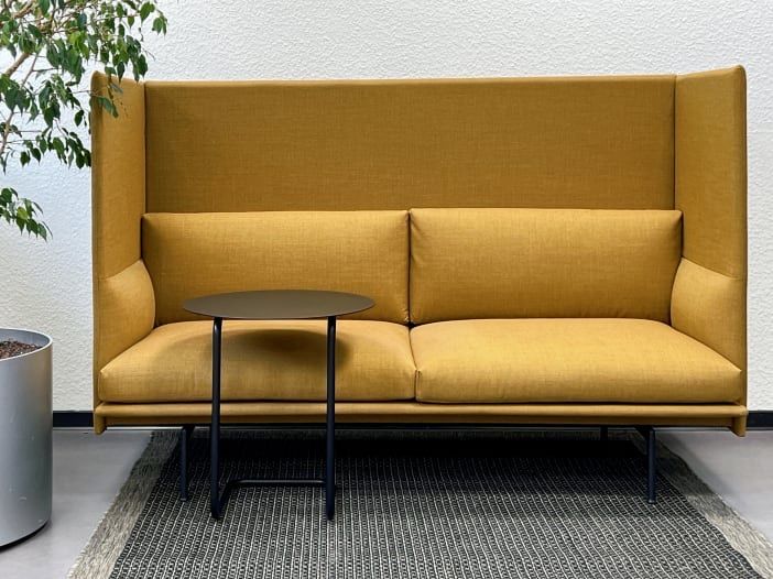 Rückzugsbereich mit gelbem Sofa, kleinem Tisch und Pflanze